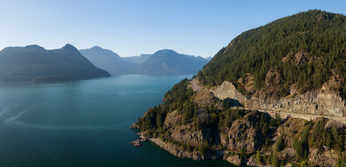 Aerial panoramic view of the Sea to Sky Highway in Howe Sound, North of Vancouver, British Columbia, Canada. Taken during a sunny summer day.