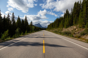 Scenic road in the Canadian Rockies during a vibrant sunny summer day. Taken in Icefields Parkway, Banff National Park, Alberta, Canada.