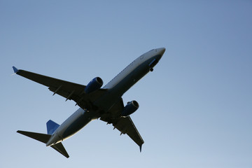 Closeup Beautiful Airplane in a blue clear sky. The plane takes off or lands for landing. Air passenger transport.