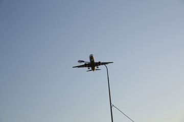 Airplane flies low over a city lighting lantern. The plane is landing. Air passenger transport.