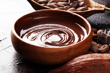 Melting chocolate, melted chocolate and chocolate swirl with stack and chips on table