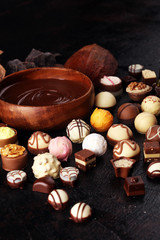 a lot of variety chocolate pralines, belgian confectionery gourmet chocolate on rustic dark background