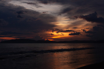 Sunset at the beach scenery with sea view, clouds, and waves. Nature beauty composition.