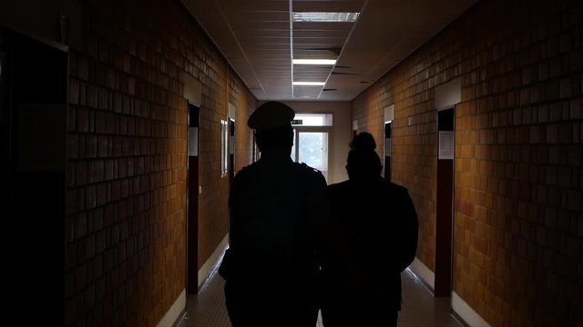 A police officer is leading a young woman away