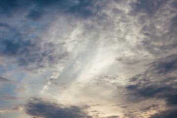 Dark clouds and sun rays on blue sky background