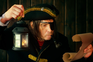 Portrait of a medieval pirate reading a scroll with a lantern in his hand