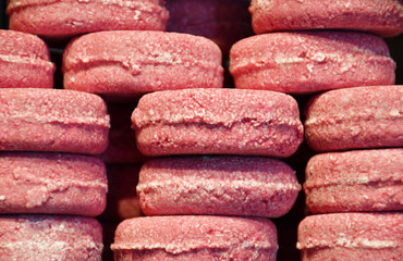 An image of several stacks of identical soap bars of bright pink and white colors made of natural ingredients