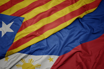 waving colorful flag of philippines and national flag of catalonia.