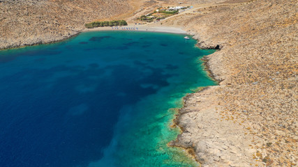 Aerial drone photo of paradise organised beach of Kaminakia with emerald clear sea and small caves, Astypalaia island, Dodecanese, Greece