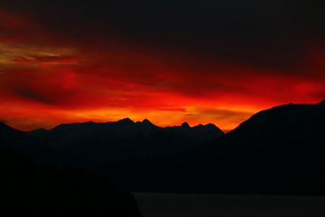 atardecer rojo y nublado sobre las montañas