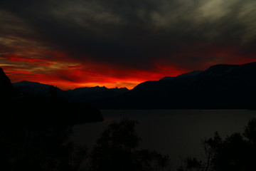 atardecer rojo y nublado sobre las montañas