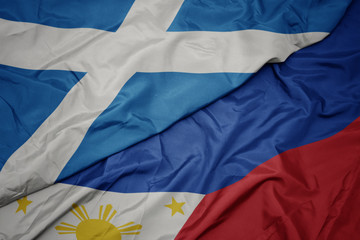 waving colorful flag of philippines and national flag of scotland.