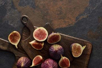 top view of delicious figs and wooden brown cutting boards on stone background