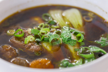 Close up view of Taiwanese Beef Noodle Soup. Asian dark soup with vegetable and stew beef.