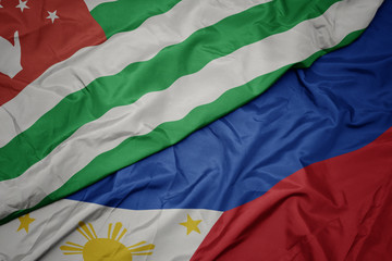 waving colorful flag of philippines and national flag of abkhazia.