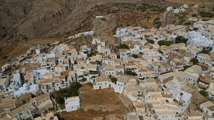 Aerial drone panoramic photo of picturesque main village or chora and castle of Amorgos island built on top of cliff overlooking the Aegean blue sea, Cyclades, Greece