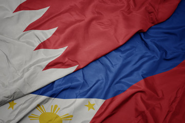waving colorful flag of philippines and national flag of bahrain.