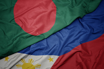 waving colorful flag of philippines and national flag of bangladesh.