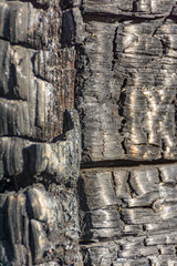Fototapeta premium The texture of burnt wood. The remains of the house burned in the fire.