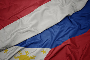 waving colorful flag of philippines and national flag of indonesia.