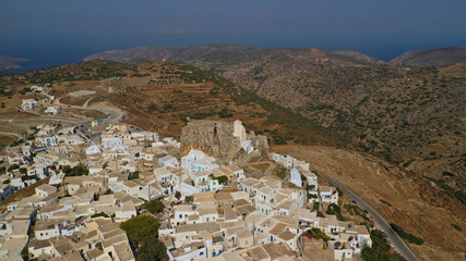 Aerial drone panoramic photo of picturesque main village or chora and castle of Amorgos island built on top of cliff overlooking the Aegean blue sea, Cyclades, Greece