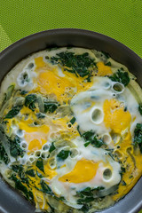 Closeup of pan with boiled eggs with spinach