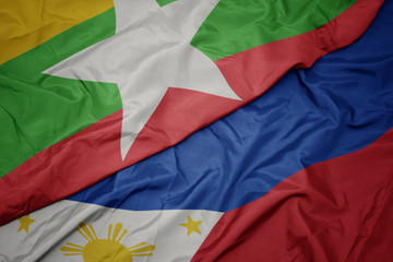 waving colorful flag of philippines and national flag of myanmar.