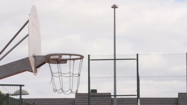 basketball ball detail entering basket from side