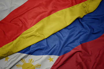 waving colorful flag of philippines and national flag of south ossetia.