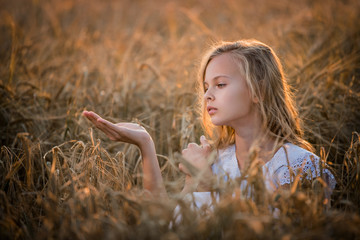 girl examines a ladybug in the palm of her hand