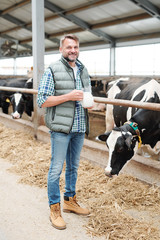 Healthy young farmer with jug of milk in dairy farm