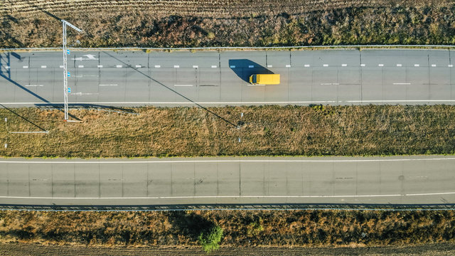 Aerial. Yellow Car Minivan Motion By The Highway. Top View.