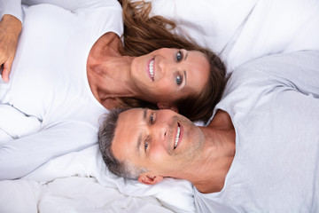 Obraz na płótnie Canvas Happy Couple Lying On Bed