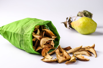 Pear Chips in a Cotton Bag and pieces of this fruits on a white background, horizontal orientation, closeup
