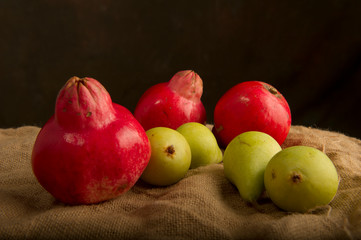Autumn fruits, pears and red pomegranates, on the burlap cloth