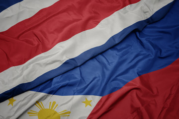 waving colorful flag of philippines and national flag of costa rica.
