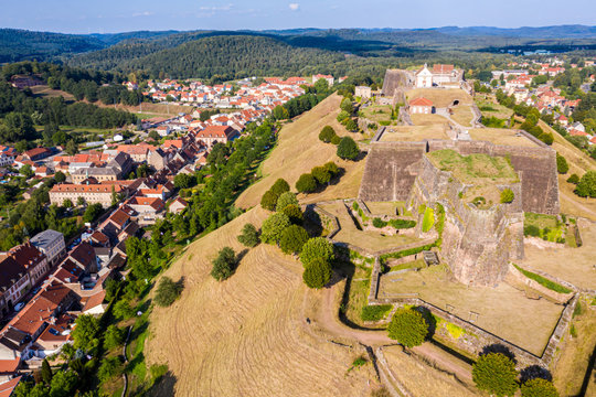 Star shaped bastions and outworks of Citadelle de Bitche, fortress and stronghold near German border in Moselle department, France. Northern Vosges Regional Nature Park and red roofs of Bitche town