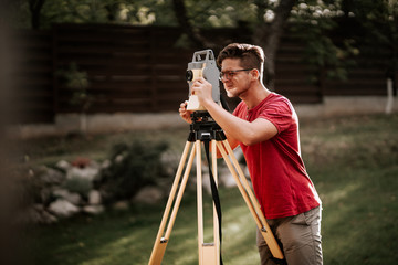 surveyor engineering equipment with theodolite and total station in a garden working on coordinates