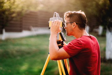 Portrait of surveyor engineer using equipment with theodolite and total station