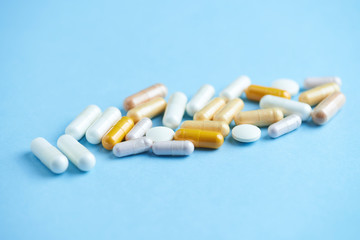 Vitamins and supplements on bright paper background. Concept for a healthy dietary supplementation. Close up. Copy space. 