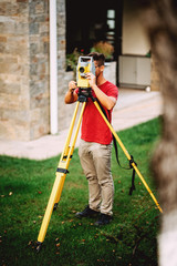 landscaping details - surveyor engineer in garden elevation working with total station theodolite
