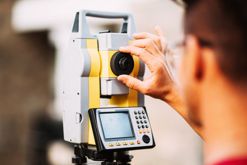 Close up details of surveyor engineer working with total station theodolite and gps system