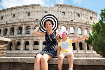 Fototapeta na wymiar Young Mother And Daughter Sitting In Front Of Colosseum