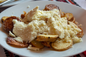 Roasted potatoes with local salt cheese prepared in local national Ukrainian restaurant, Carpathian region, Ukraine