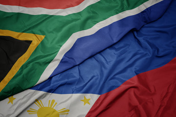 waving colorful flag of philippines and national flag of south africa.