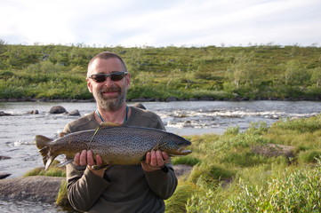 Happy fisherman with salmon on the Kola Peninsula.