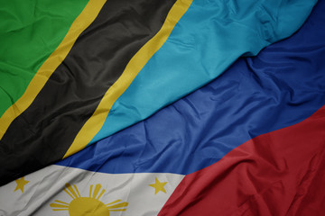 waving colorful flag of philippines and national flag of tanzania.