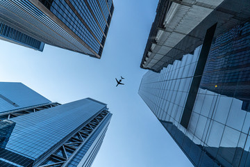 Plane Flying Above New York Buildings - obrazy, fototapety, plakaty