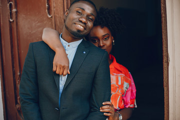 A young and stylish dark-skinned couple standing in a sunny city