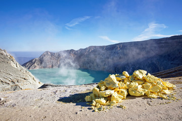 The sulfuric lake of Kawah Ijen vulcano in East Java with sulfur stone in foreground, Indonesia